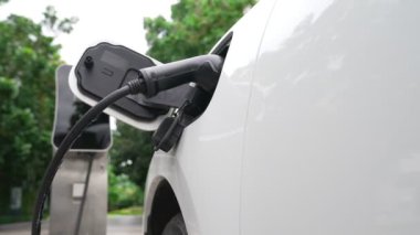 Elektrikli araba parkı ve şarj istasyonunun yanında şarj edilen enerji konseptinin sürdürülebilirliği. Çevresel koruma için yenilenebilir enerji tarafından kullanılan elektrikli araç.