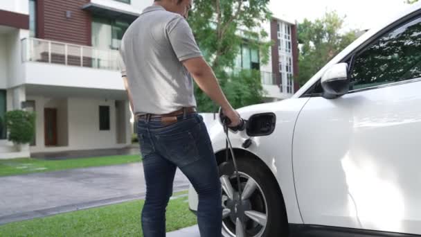 Den Progressiva Mannen Fäster Utsläppsfri Strömkontakt Batteriet Elfordonet Sitt Hem — Stockvideo