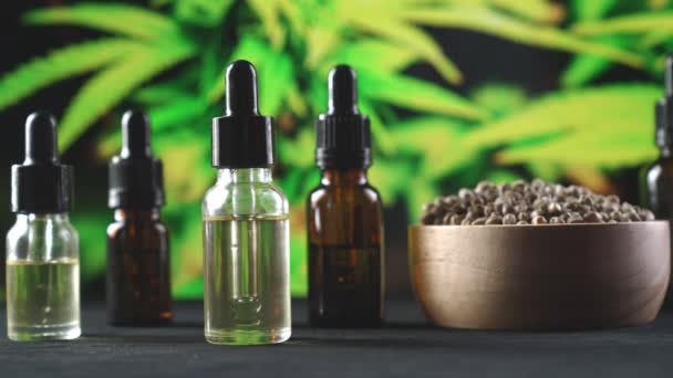 大麻植物 大麻叶的合法大麻产品 Cbd油瓶 各种尺寸 木制大麻籽碗 桌上有大麻叶 有大麻植物背景 可供复制 — 图库视频影像