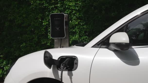 在家用充电站旁边停放电动车和充电 使能源概念逐渐具有可持续性 利用可再生能源进行环境保护的电动汽车 — 图库视频影像