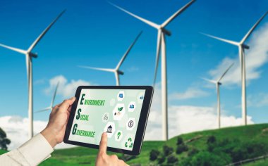 Çevre tasarrufu ve ESG iş konsepti için yeşil iş dönüşümü. İşadamı, çevre dostu yönetime ve alternatif temiz enerji kullanımına yönelik kurumsal bir hedef belirlemek için tablet kullanıyor.