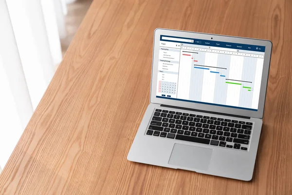 Project planning software for modish business project management on the computer screen showing timeline chart of the team project