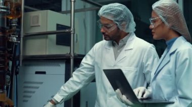 Kimyasal ve biyomedikal deneyler için tedavi laboratuvarında çalışan profesyonel üniformalı iki bilim adamı.