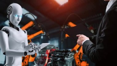 Cybernated industry robot and human worker working together in future factory . Concept of artificial intelligence for industrial revolution and automation manufacturing process .