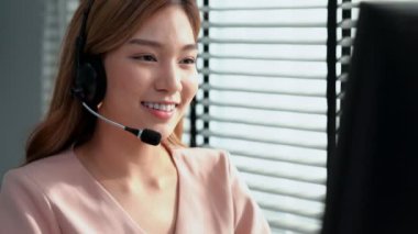 Competent female operator working on computer and while talking with clients. Concept relevant to both call centers and customer service offices.