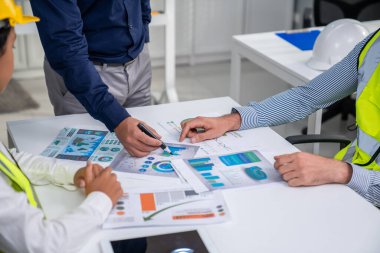 Engineers and competent employer discussing plans and blueprints together with tablet in the office. Concept of team contribution of ideas for engineering project.