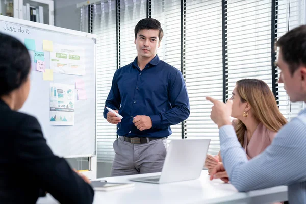 Competent office workers from various nationalities are debating, discussing and brainstorming in the meeting room. A group of employees is collaborating to achieve their business objectives.