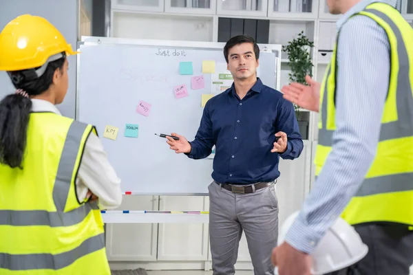 A team of investor and competent engineers brainstorming on the whiteboard to find new ideas and making plans. The idea of a team gather ideas together.