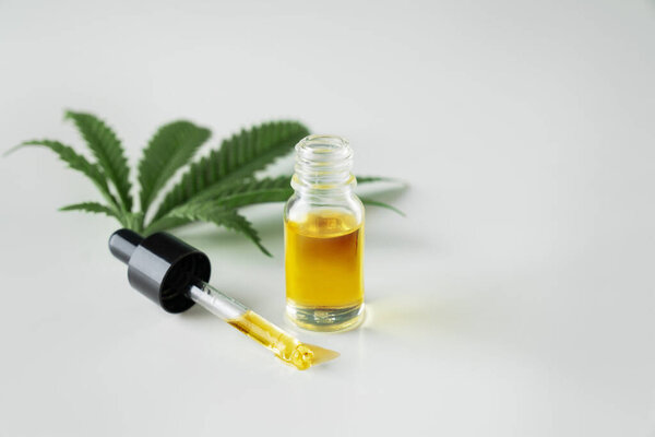 Лист конопли конопли конопли конопли с контейнером масла CBD с крышкой капельницы на белом фоне. Легализованная марихуана.