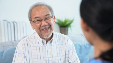 A young female doctor inquires about personal information of a contented senior at home. Medical care for the elderly, elderly illness, and nursing homes, home care.