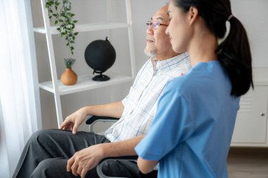Caring nurse and a contented senior man in a wheel chair at home, nursing house. Medical for elderly senior, home care for pensioners.