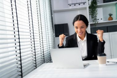 This photo depicts a young African American and competent woman at her workplace. A female employee in her office at work.