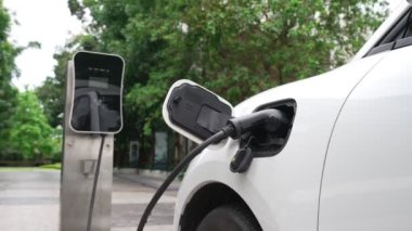 Elektrikli araba parkı ve şarj istasyonunun yanında şarj edilen enerji konseptinin sürdürülebilirliği. Çevresel koruma için yenilenebilir enerji tarafından kullanılan elektrikli araç.