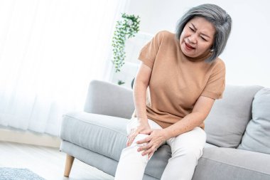 An agonizing elderly woman is experiencing chest pain. Medical attention, medical service for seniors.